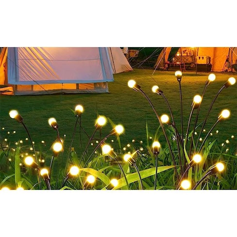 solarne led lampe prikazane kako svjetle u vrtu sa toplom svjetlošću